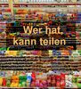 Volle Supermarkregale. Davor der Schriftzug: "Wer hat, kann teilen"